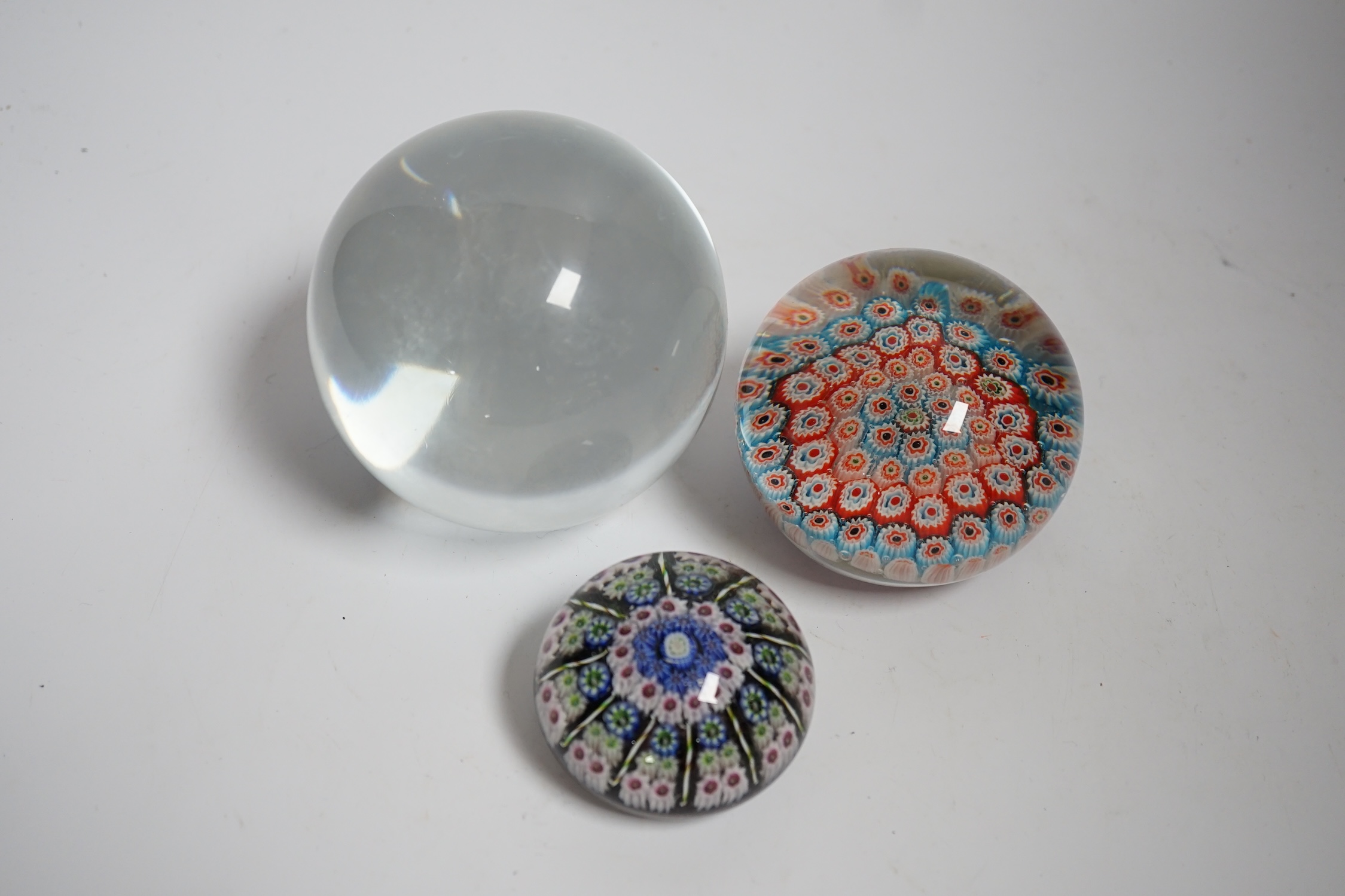Two millefiori paperweights and a glass ball, largest 10cm in diameter